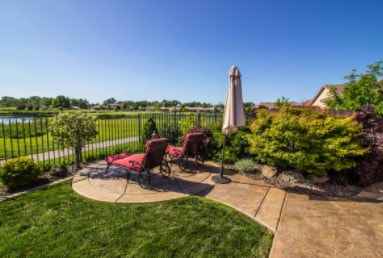 Circular patio overlooking lake adjoins driveway